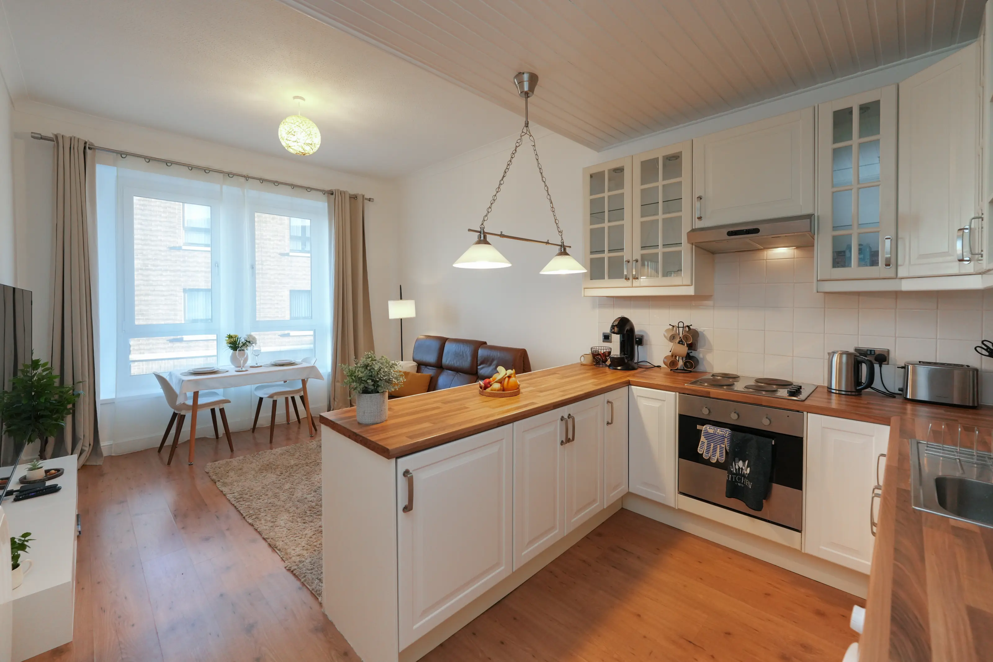 Open-plan kitchen-lounge with dining area and modern appliances